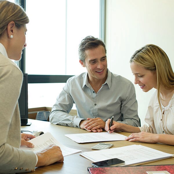 couple signing papers at desk