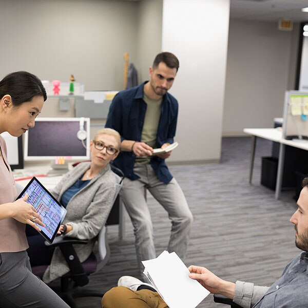 Business people meeting, looking at info on a tablet