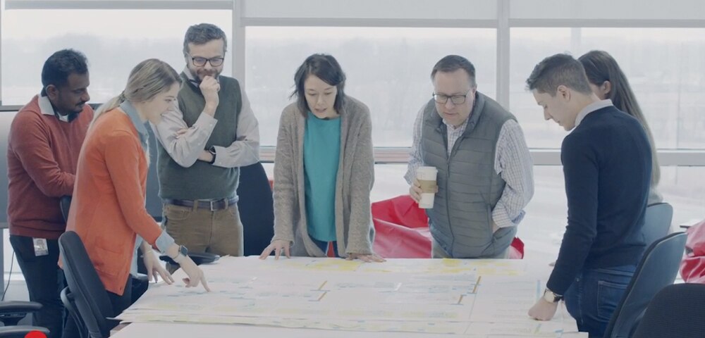 Group of co-workers reviewing assets on a table in a conference room