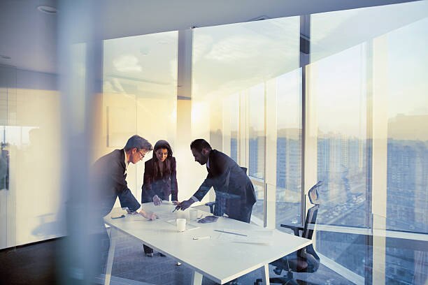 Group of co-workers reviewing assets on a table in a conference room