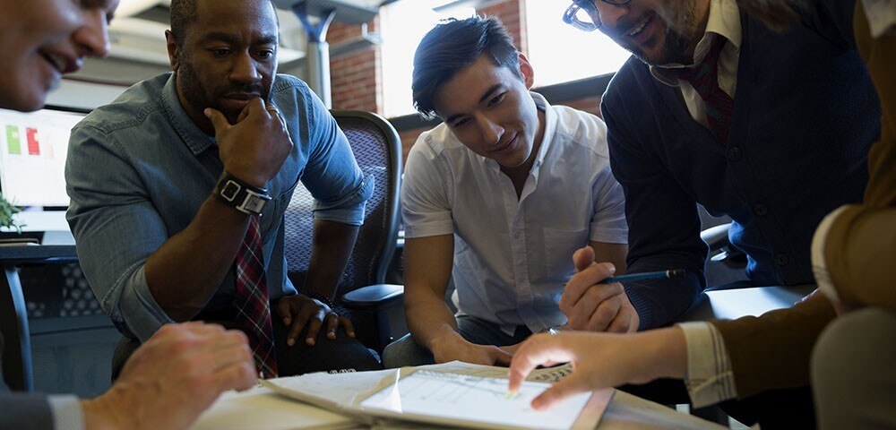 Colleagues gather around a tablet