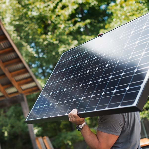 A man carrying a solar panel
