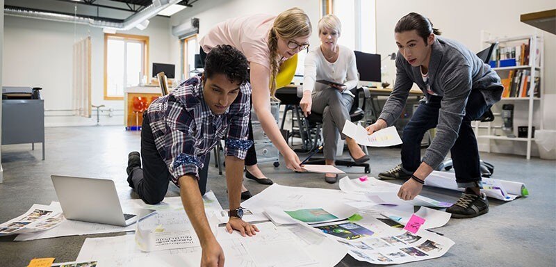 Team bending over scattered papers on the floor