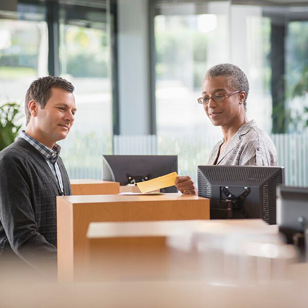 Man interacting with a female bank teller at a bank branch