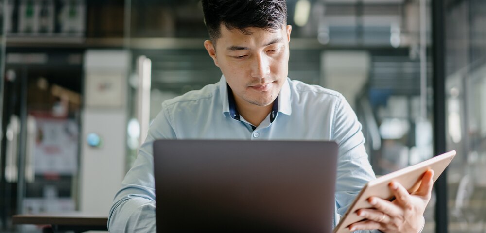Person working on laptop and tablet