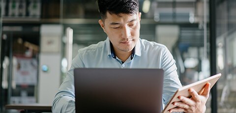 Person working on laptop and tablet