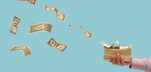 Hand holding stack of dollar bills