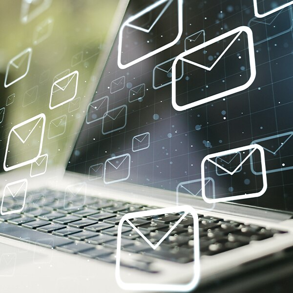 Laptop with overlay of email icons