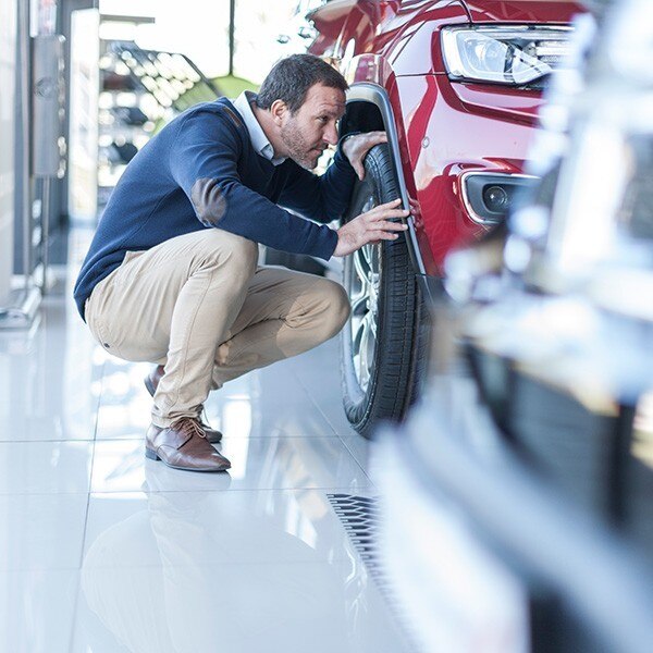 Man inspecting car at auto dealership
