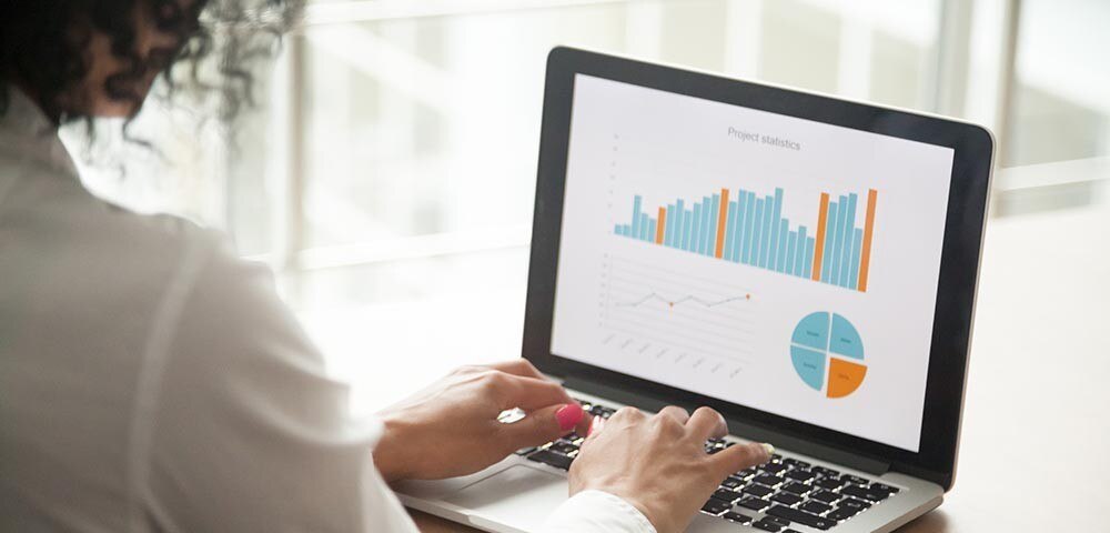 Woman creating financial charts on laptop
