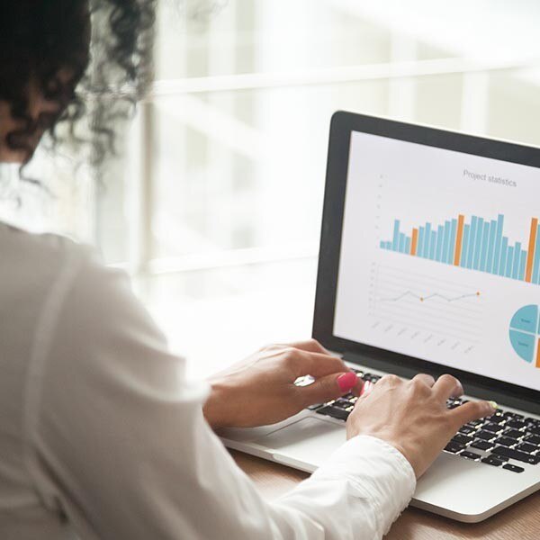 Woman creating financial charts on laptop