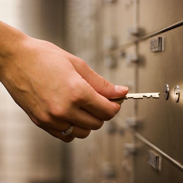 Hand unlocking a safe deposit box