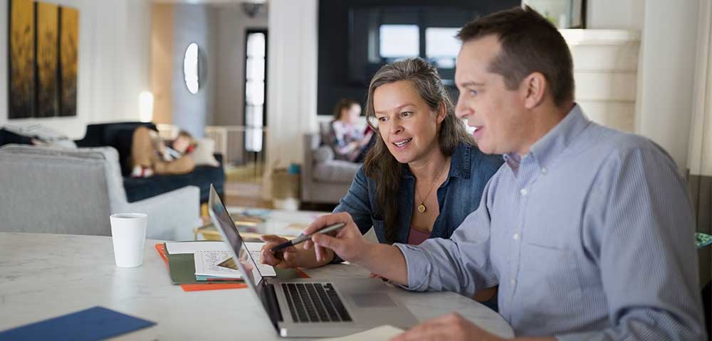 man and woman working on computer together