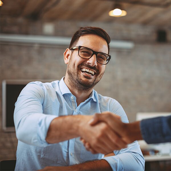 Man with wearing dress shirt and glasses shaking hands