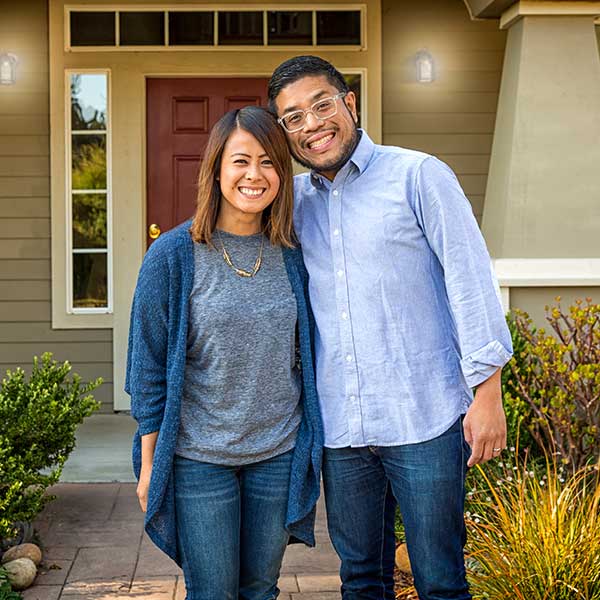 Man and woman in front of home