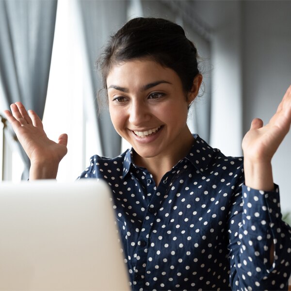 a woman rejoicing at her computer