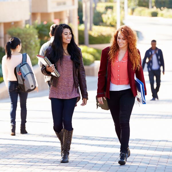 Two young girls walking along a college campus