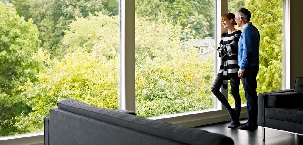 2 people looking out window by couch