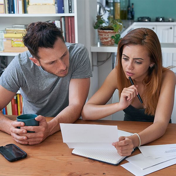 Young couple sitting at a table looking at papers