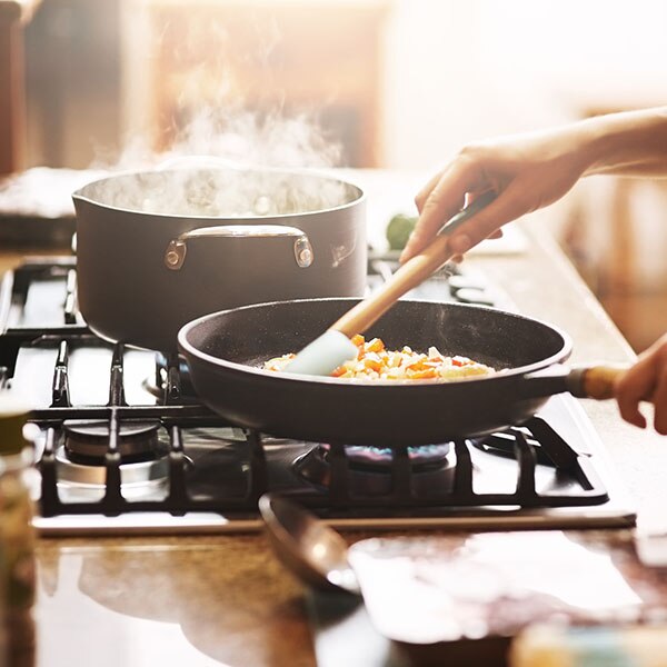 Woman cooking food on a stove