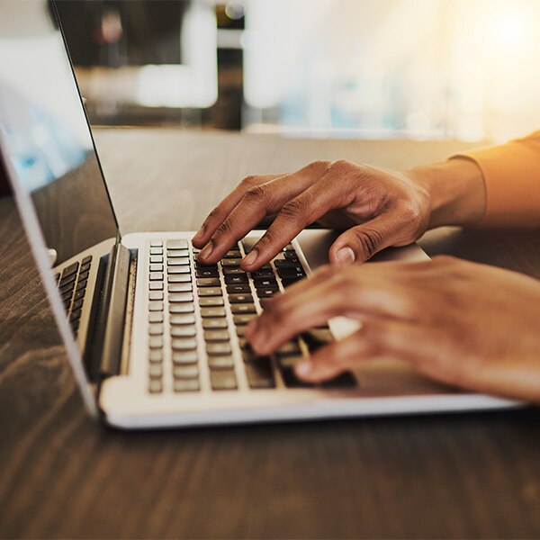 hands tapping on laptop keyboard