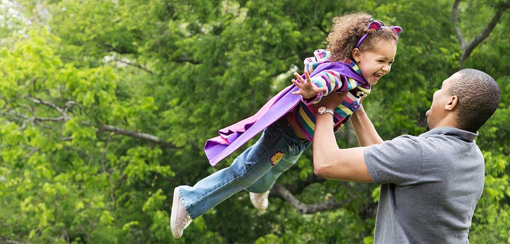 Father holding daughter overhead