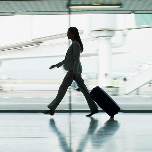 Woman walking through airport with luggage