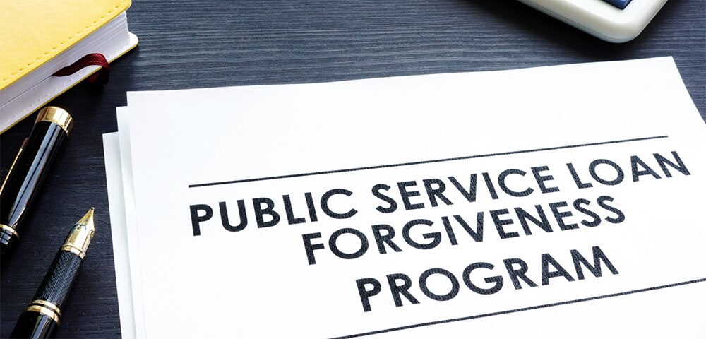 Close‑up of a document labeled ‘Public Service Loan Forgiveness Program’ with a calculator nearby.