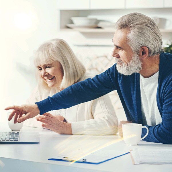 older couple reviewing the screen of a man's laptop