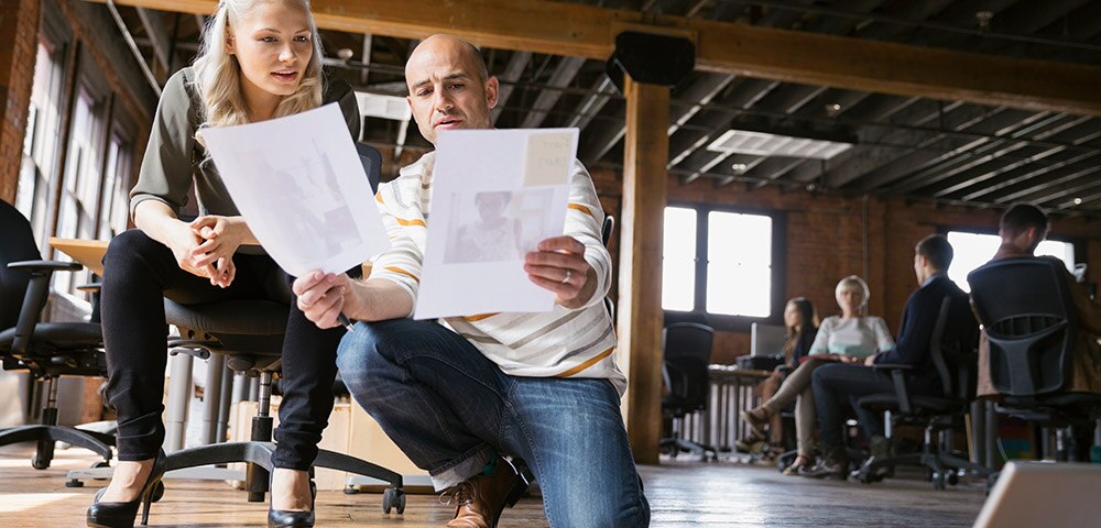 Man and woman comparing papers