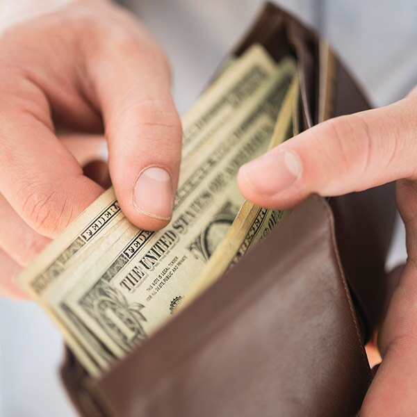 Hands pulling money out of a wallet