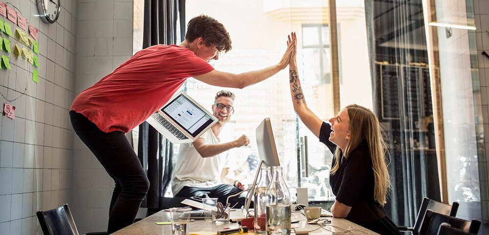 coworkers high-fiving in celebration