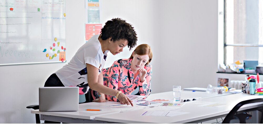 two women reviewing documents on a table