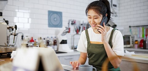 Woman on phone working on laptop