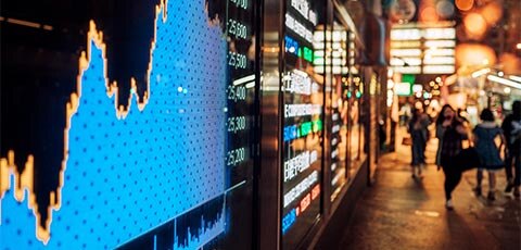 Crowd walking street in front of digital displays