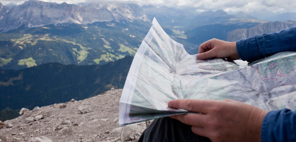 man with map overlooking a mountain