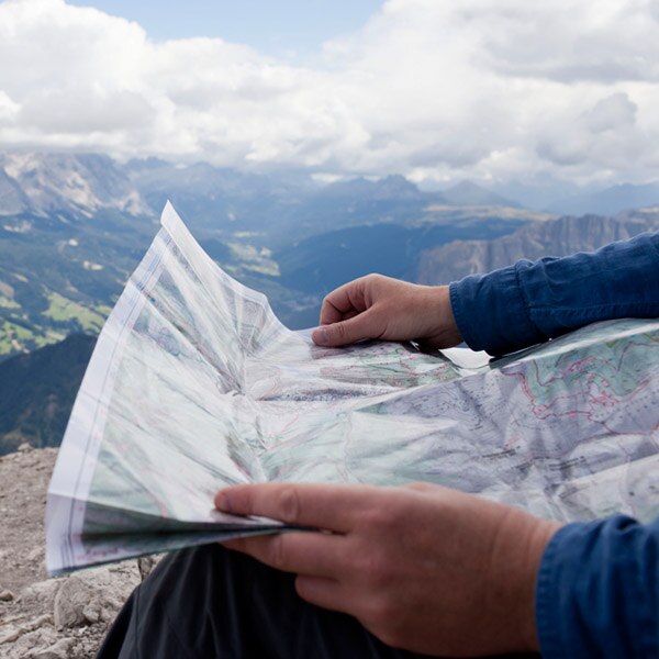 Man with map overlooking a mountain