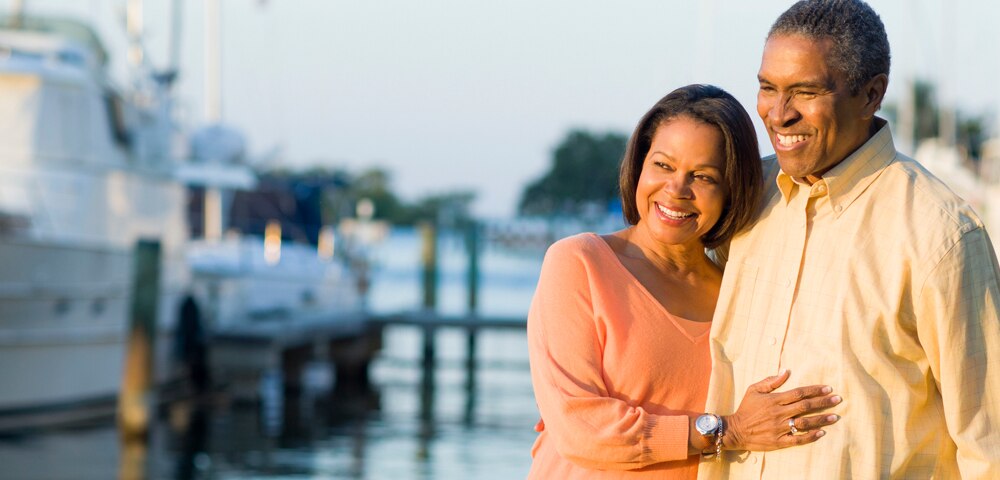 husband and wife on yacht dock hugging