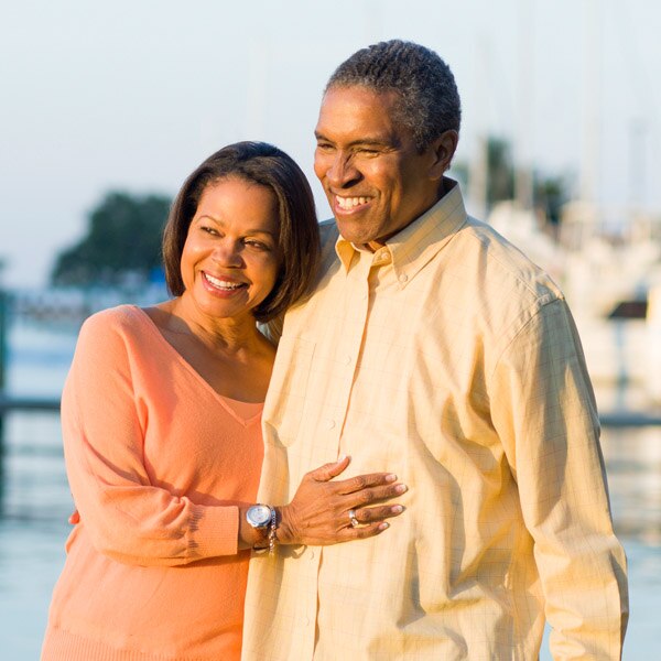 Husband and wife on yacht dock hugging