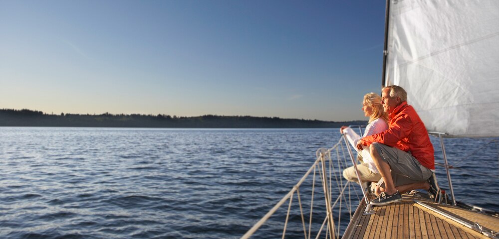 couple on a sailboat looking out at the water