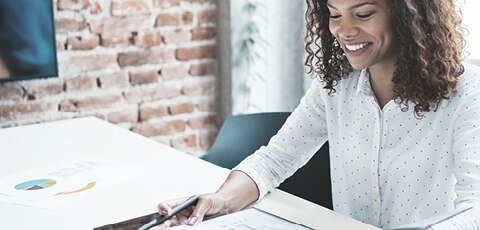 Smiling woman at table reading report