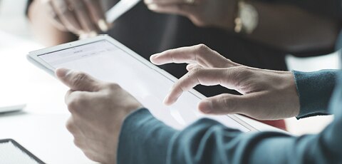 Close-up of someone typing on a tablet