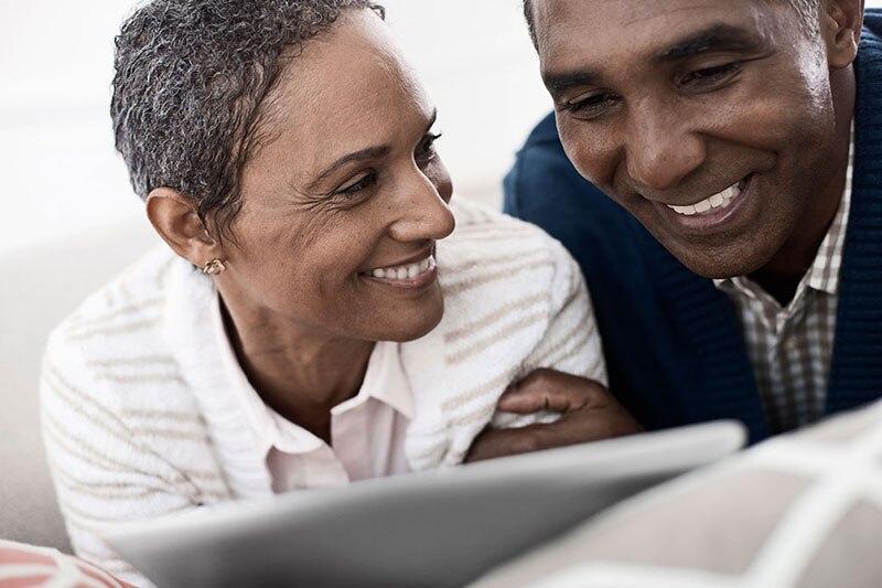 Couple working on a tablet smiling