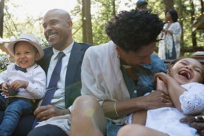 family sitting together with mom tickling child